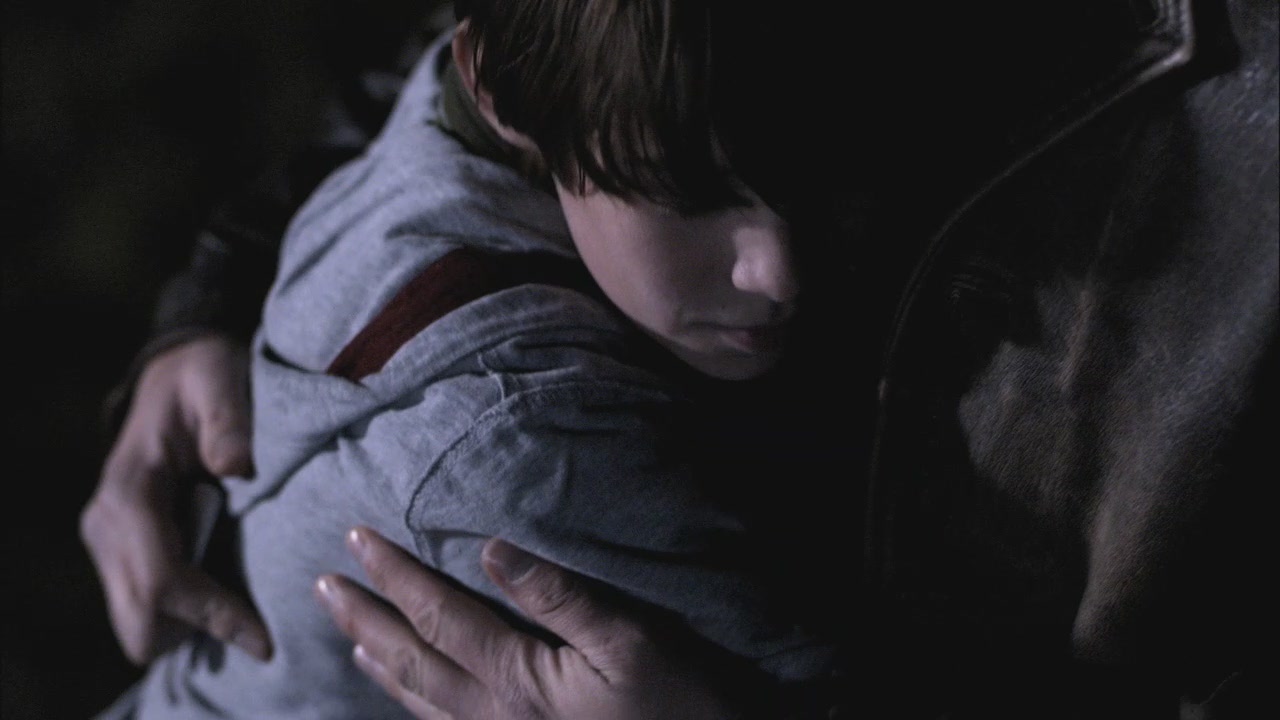 Close-up of young Sam hugging adult Dean