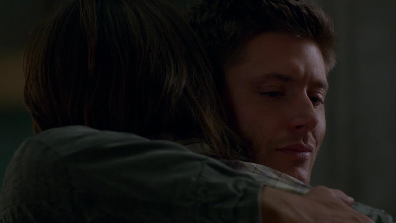 A smiling Dean hugging Sam
